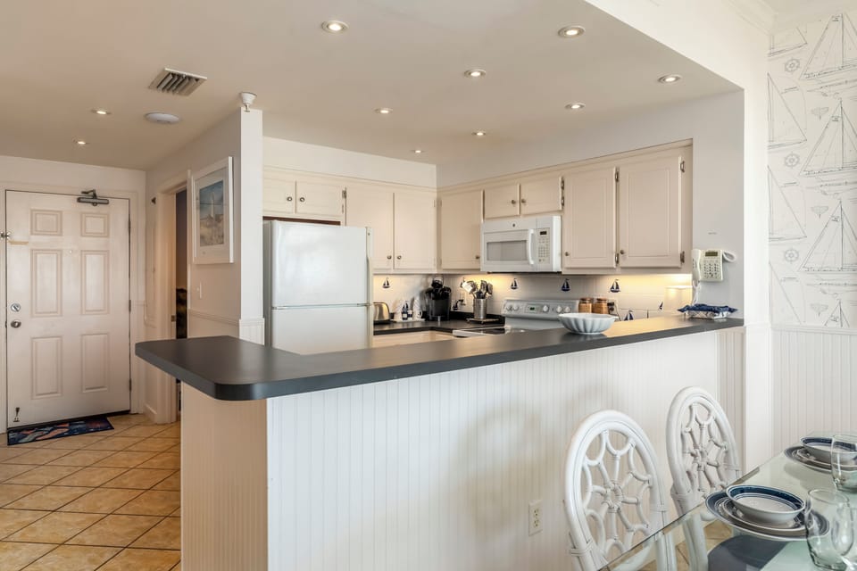Your bright kitchen awaits with modern appliances and a breakfast bar perfect for morning coffee and meal prep.