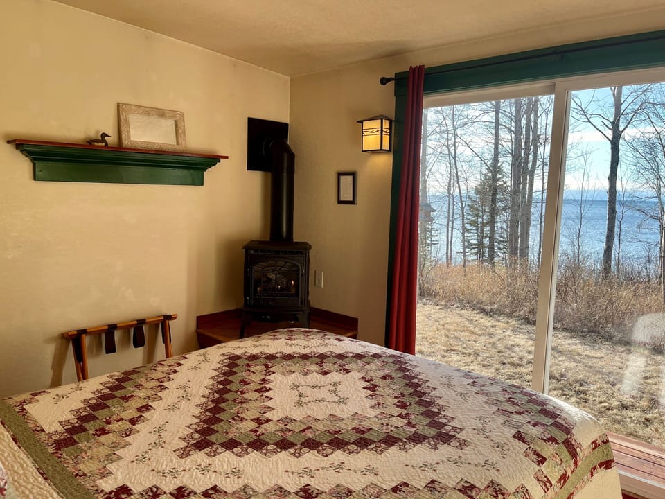  Lake Facing Bedroom in Spring
How can it get better than this. Imagine laying on the plush queen bed reading a good book within the glow of the gas stove. As you look out the patio door you have Lake Superior laid out in front of you in Cottage #3.