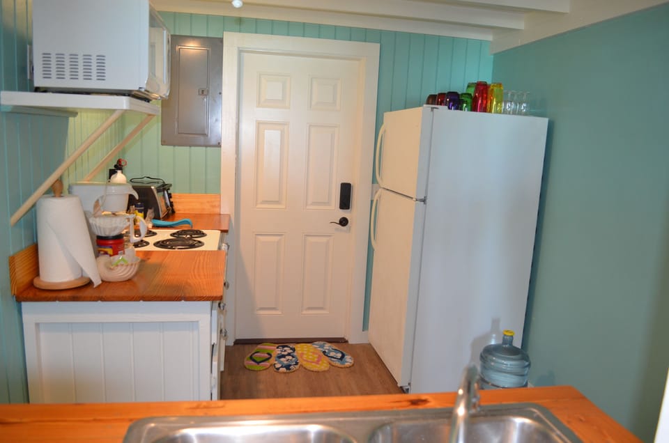 Well equipped kitchen with range, microwave, toaster oven, and utensils.