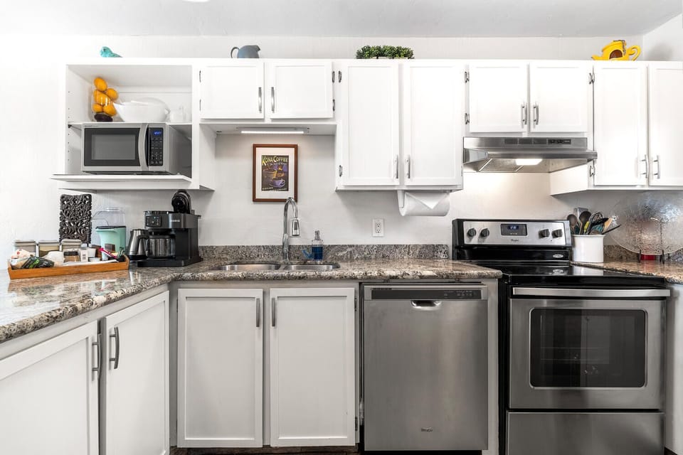 White cabinets, gray granite countertops & stainless appliances blend well