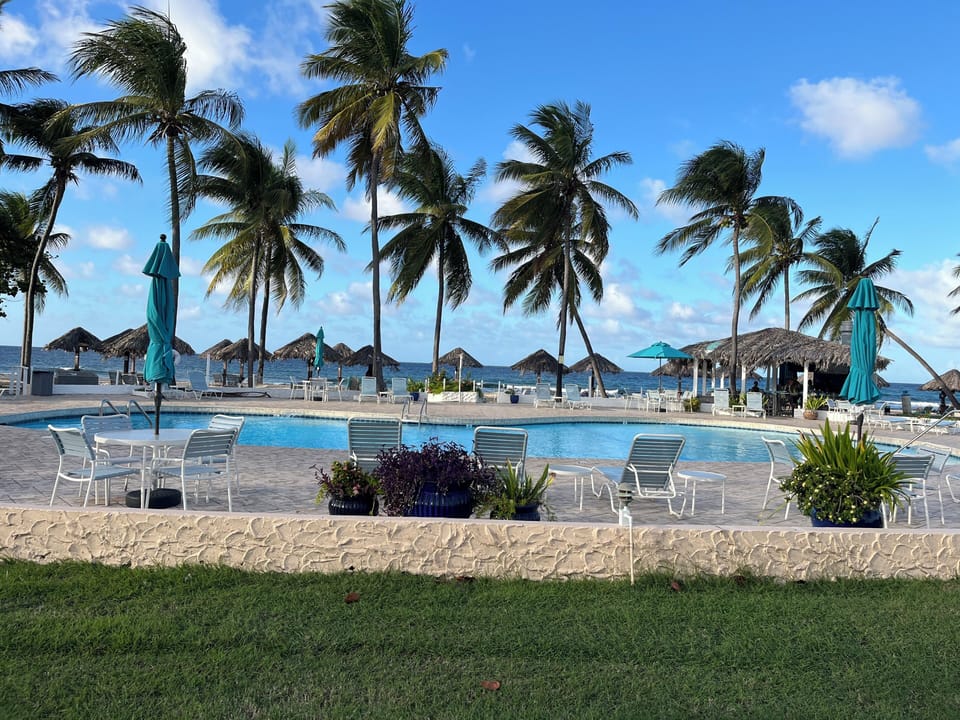 Large beachfront swimming pool with spacious sun deck and poolside beach bar