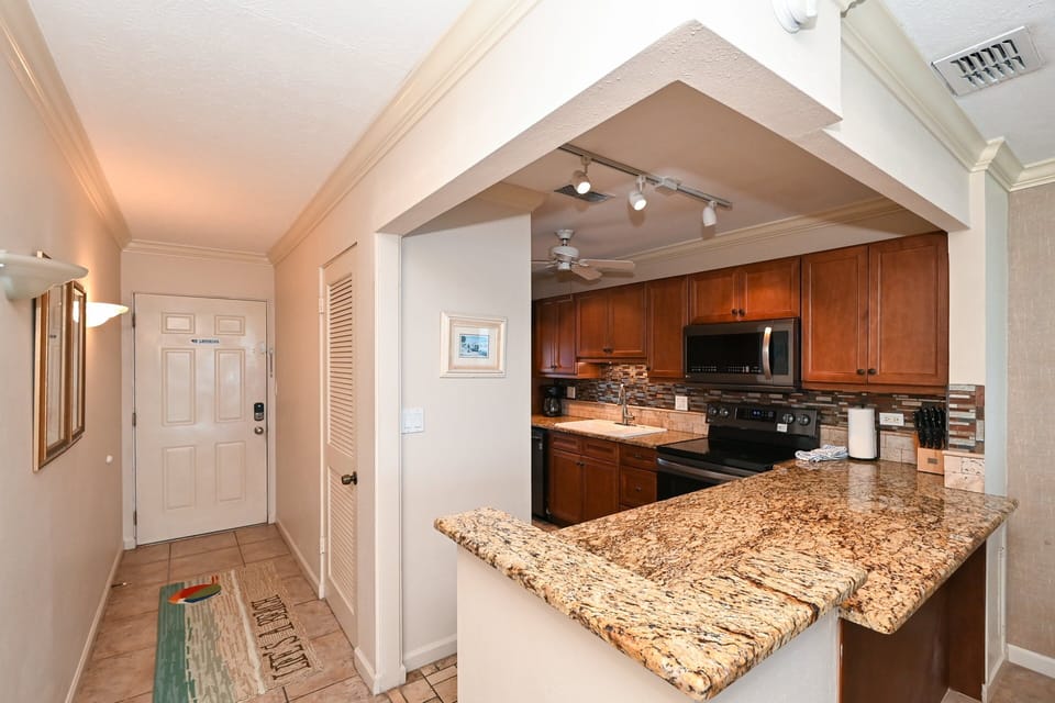 Modern, renovated, fully equipped kitchen with granite counters, glass tile backs splash...