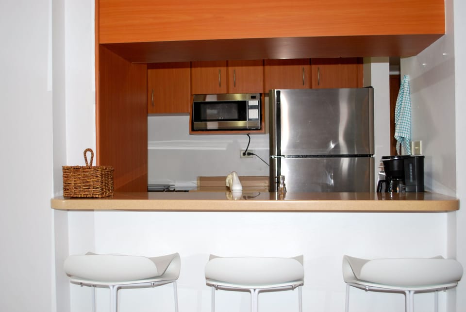 Kitchen with counter and three stools. 