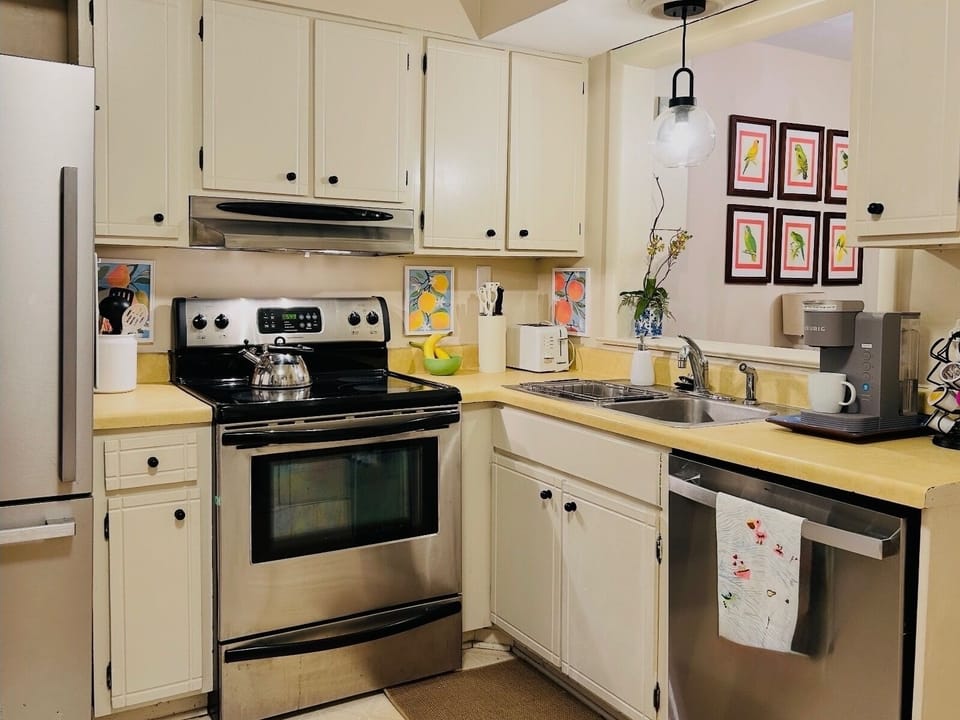 Kitchen with full-size stainless appliances, dishes, glassware and cookware.