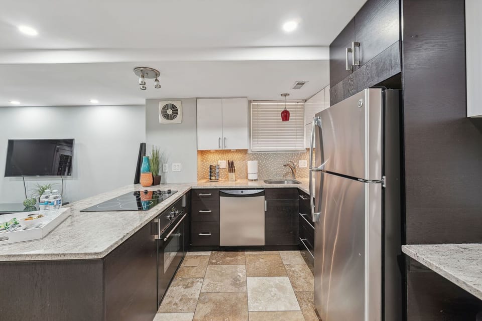 Modern kitchen with brick accent wall, and sleek finishes.