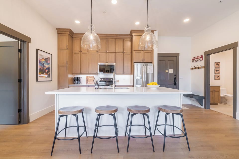 Remodeled kitchen with a large quartz island, seating, and custom cabinetry.