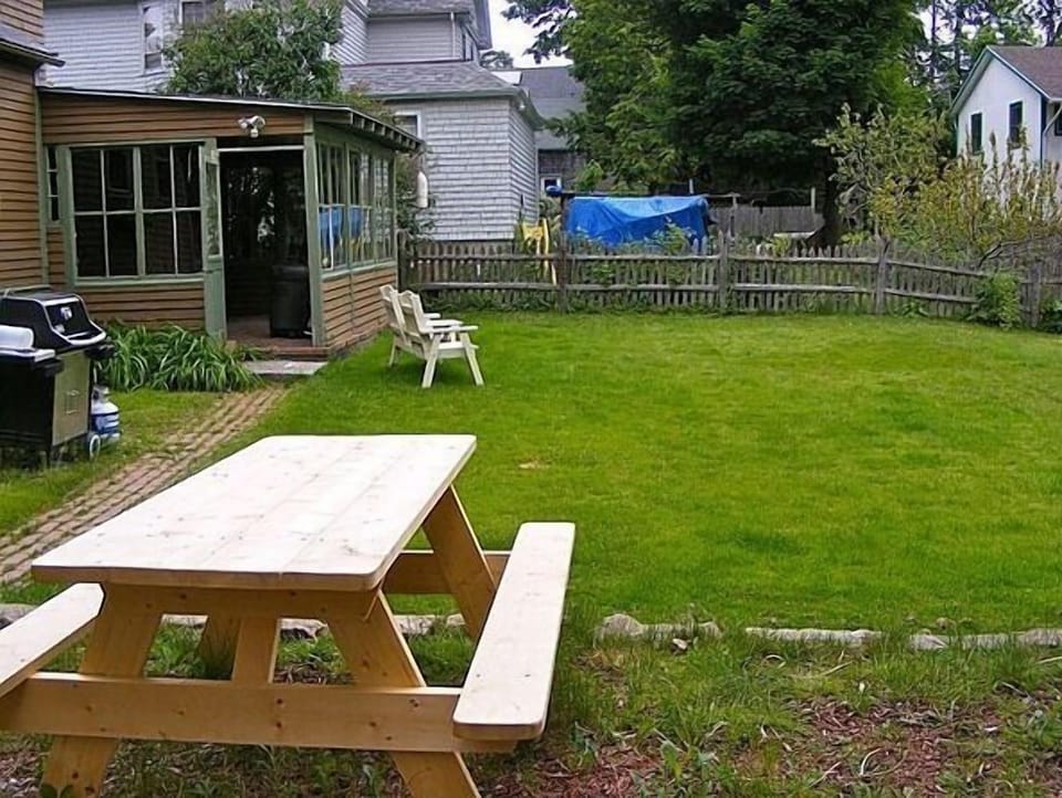 Backyard with grill, 2 picnic tables, outdoor seating