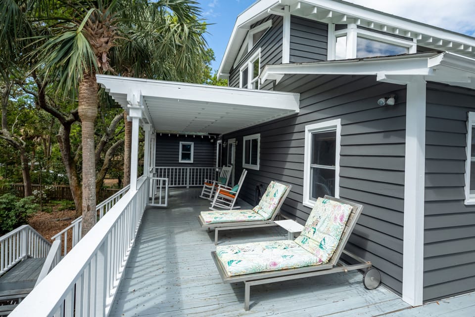 Partially covered front porch. 2 loungers, 2 rocking chairs.