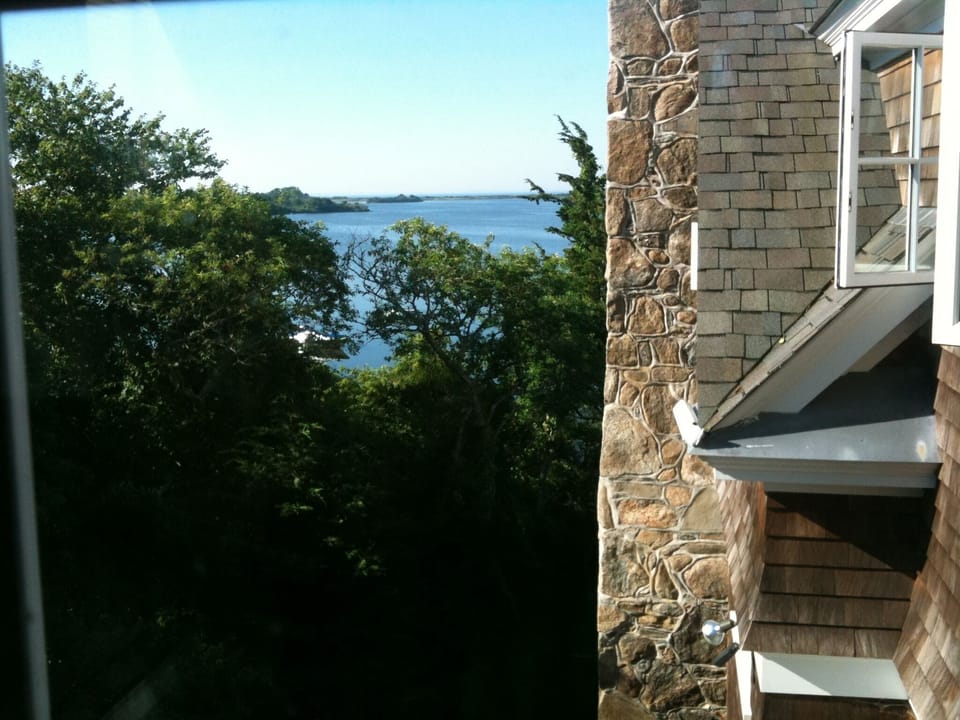 Serene water views framed by trees and classic coastal stone architecture