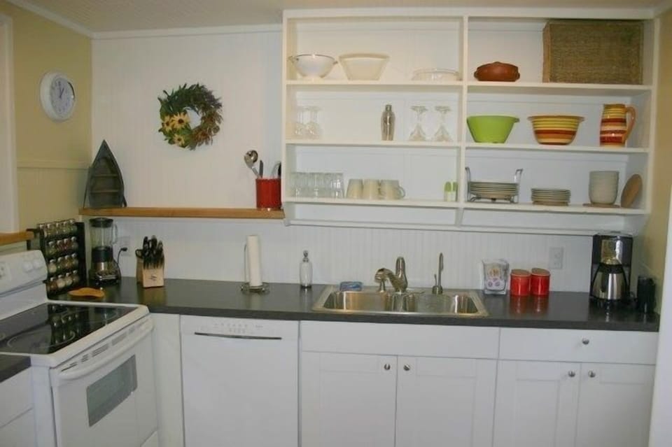 Kitchen with plenty of dishes, dishwasher, coffee, tea, and spices