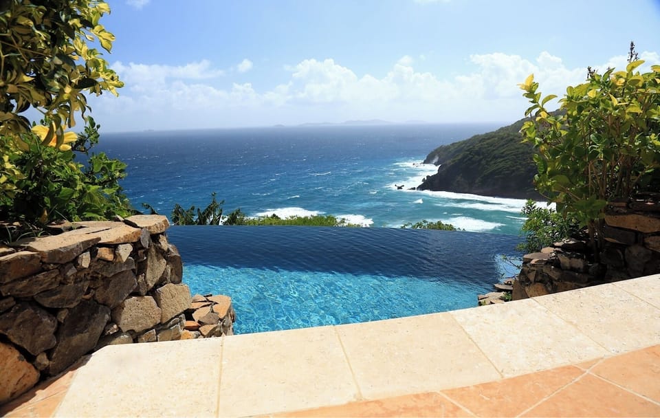 Full length infinity edge salt water pool slides into the ocean 300 feet below