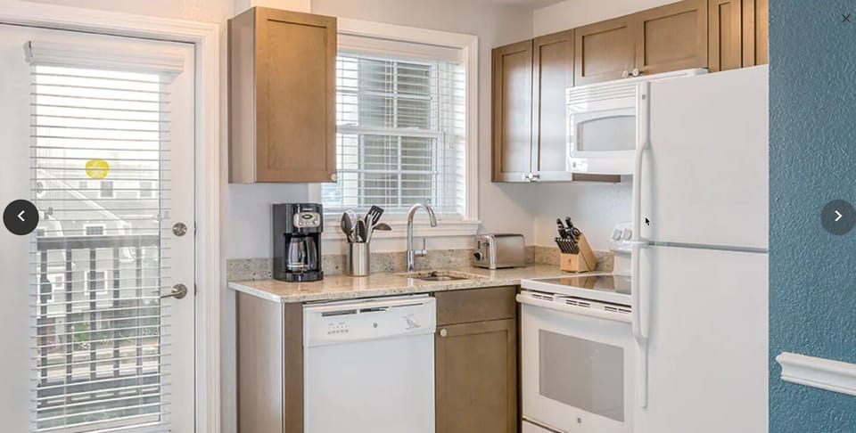 Kitchen fully stocked with utensils cooking apparatus.