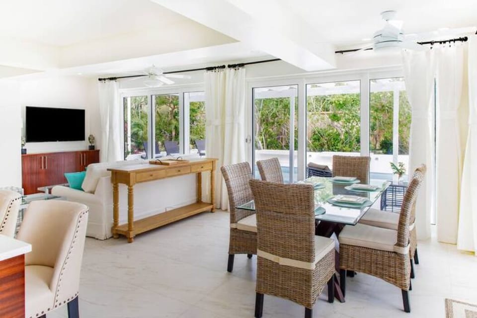 Gather around a spacious dining table for six, positioned in an open area that welcomes the natural light from the outside