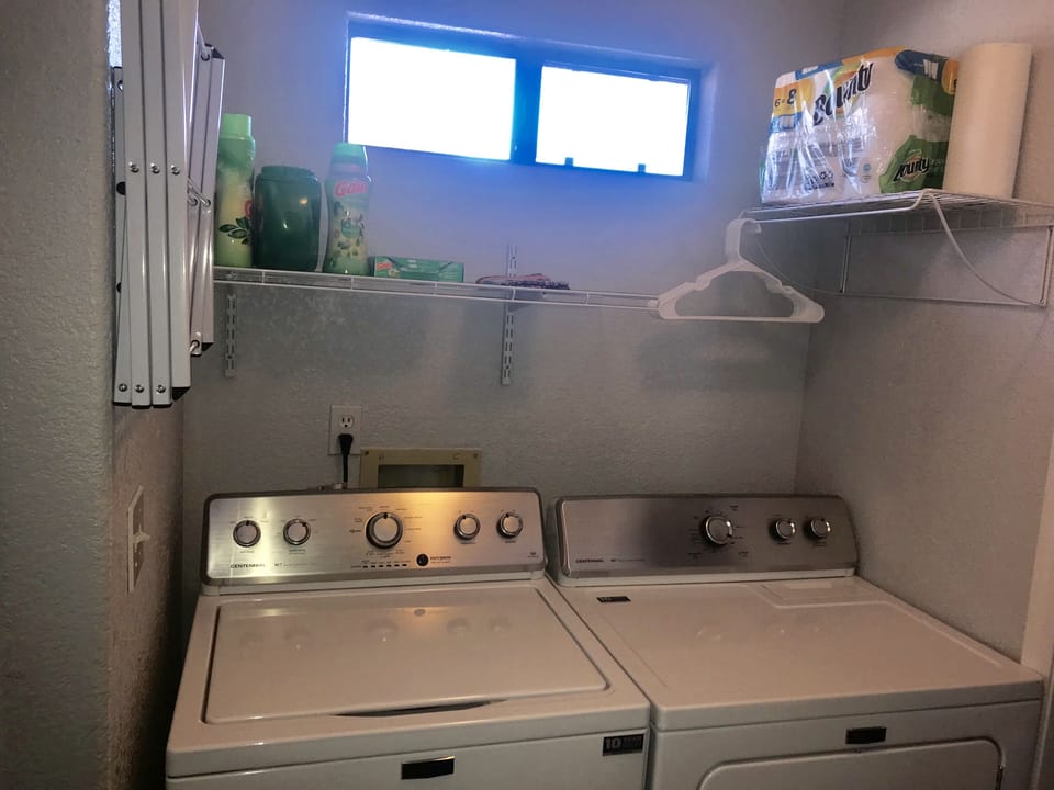 Indoor laundry room with drying racks and extra storage 