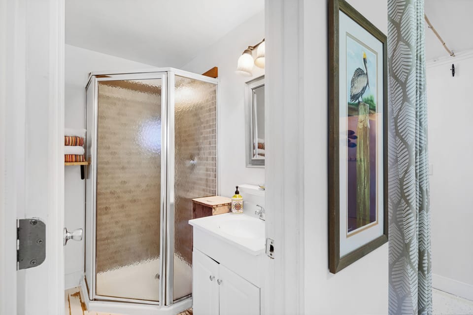Bathroom has a shower, single vanity and bath towels for 4 guests. 