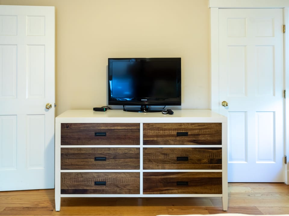 Dresser and 32-inch Samsung TV in first floor queen bedroom