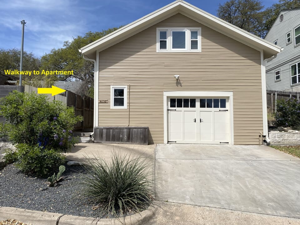 Garage building with upper level apartment showing walkway to apartment.