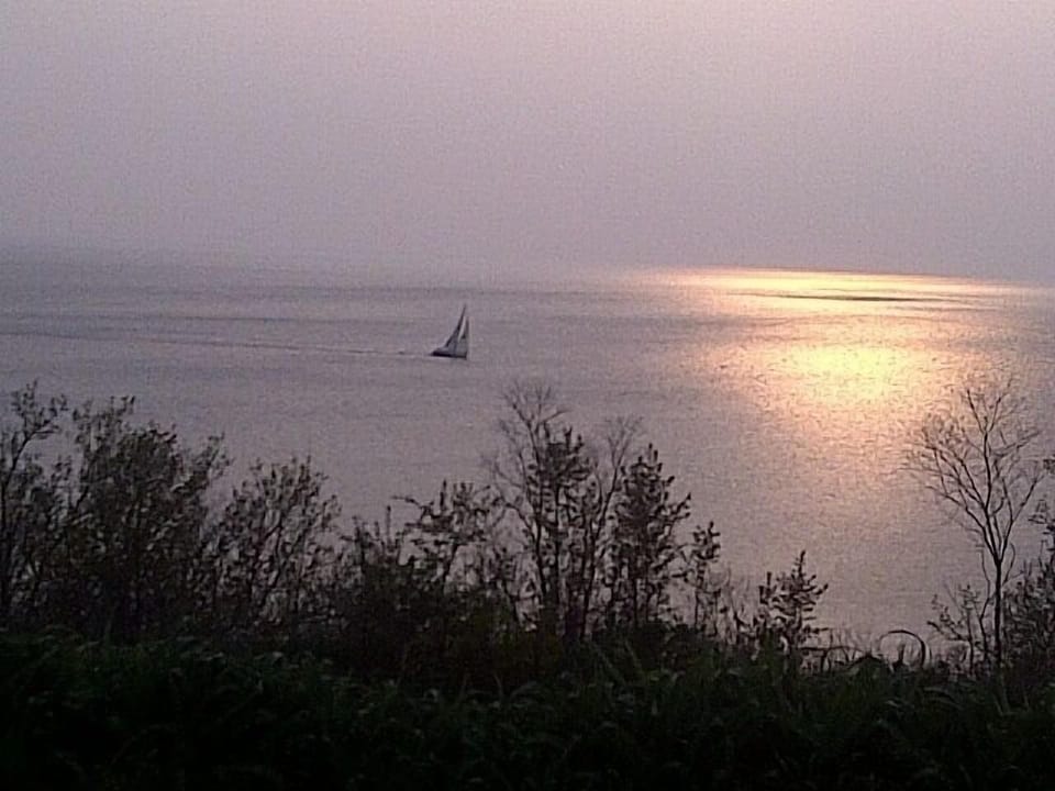 Sun setting on Lake Michigan and sailboat from the bluff (Lake Street)