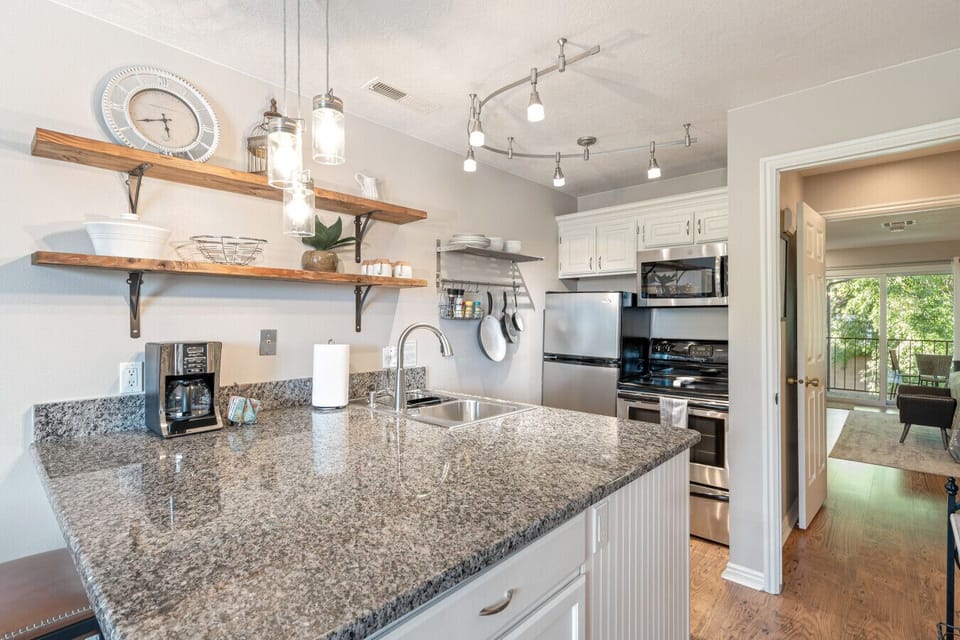 Open floor plan with granite countertops & a fully stocked kitchen for cooking
