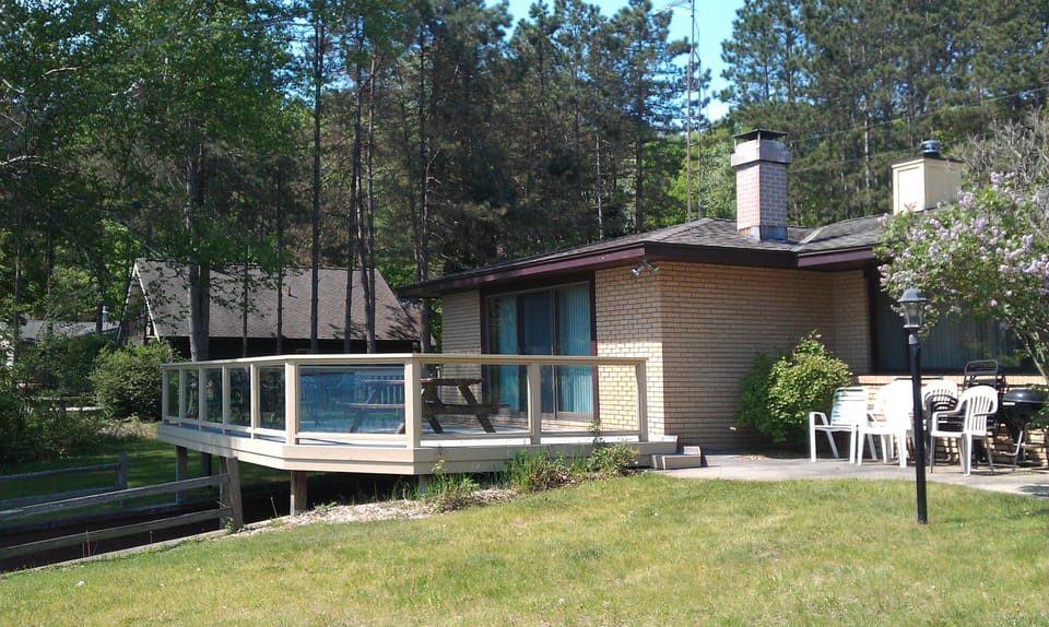 Large deck with glass railings overlooking  Walloon lake