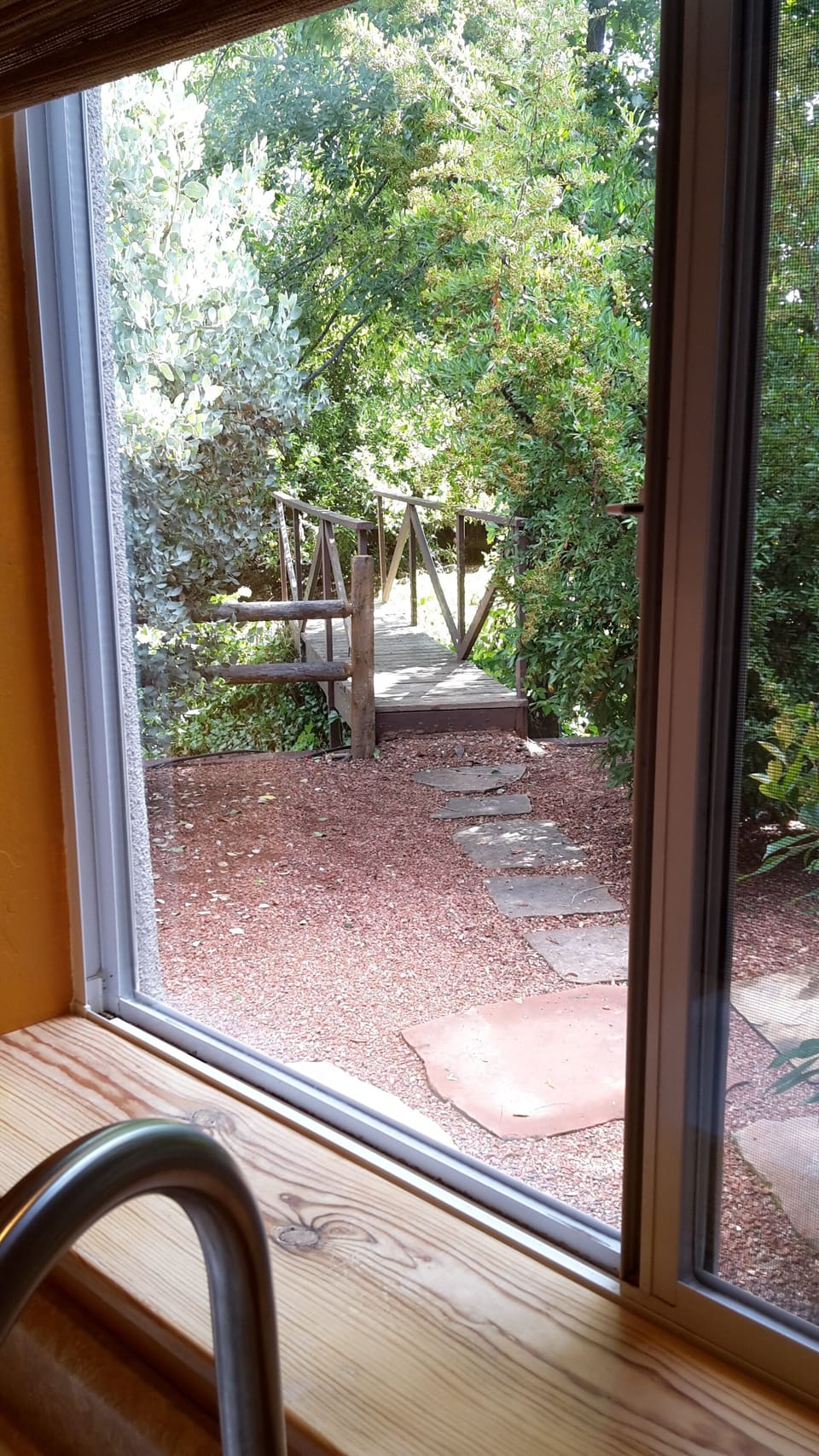 View out the kitchen window toward the little bridge to the lower garden