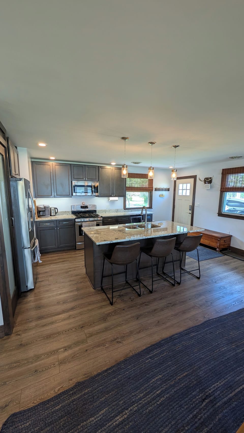 Entryway and full kitchen with modern, updated appliances and island seating 