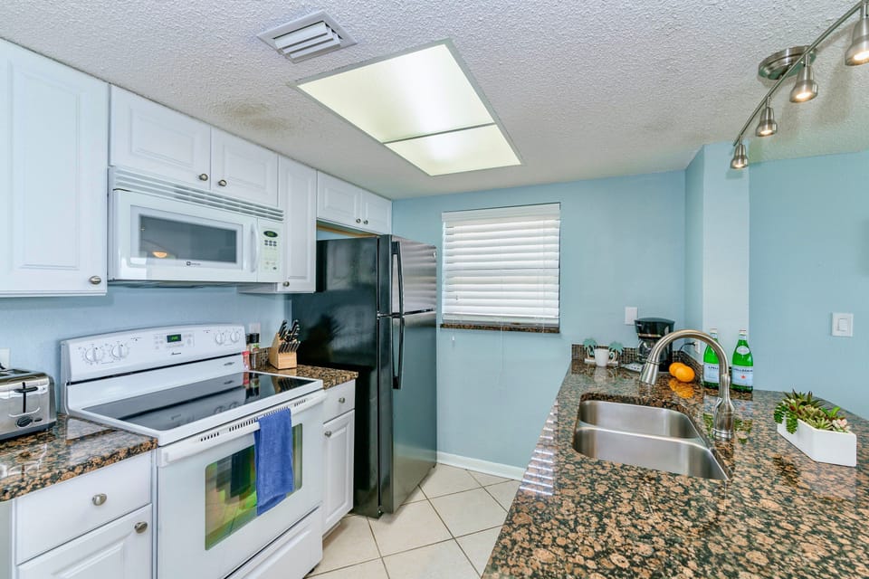 Fully equipped kitchen with modern appliances, granite countertops, and ample storage space.