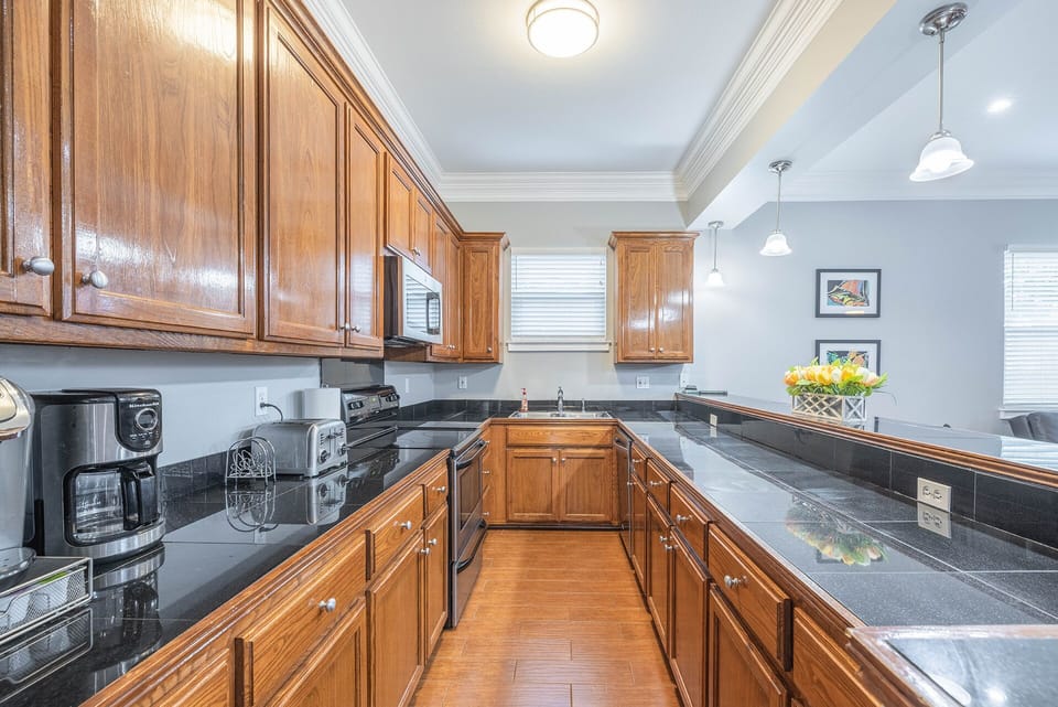 Kitchen view of black granite counter tops with small appliances 