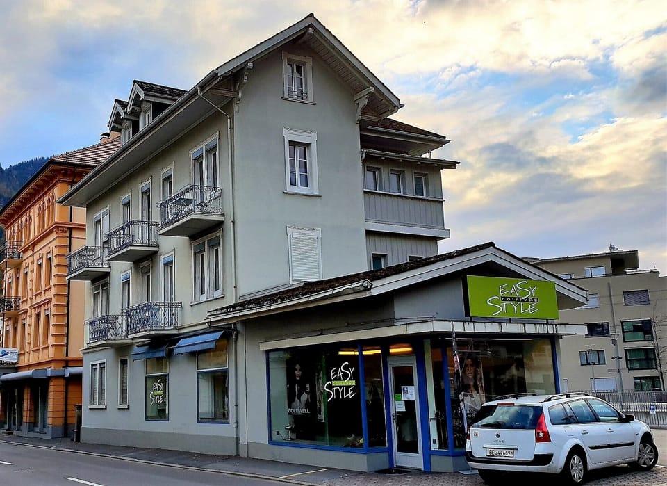 Apartment building, the entrance to the parking is where the white car is drivin