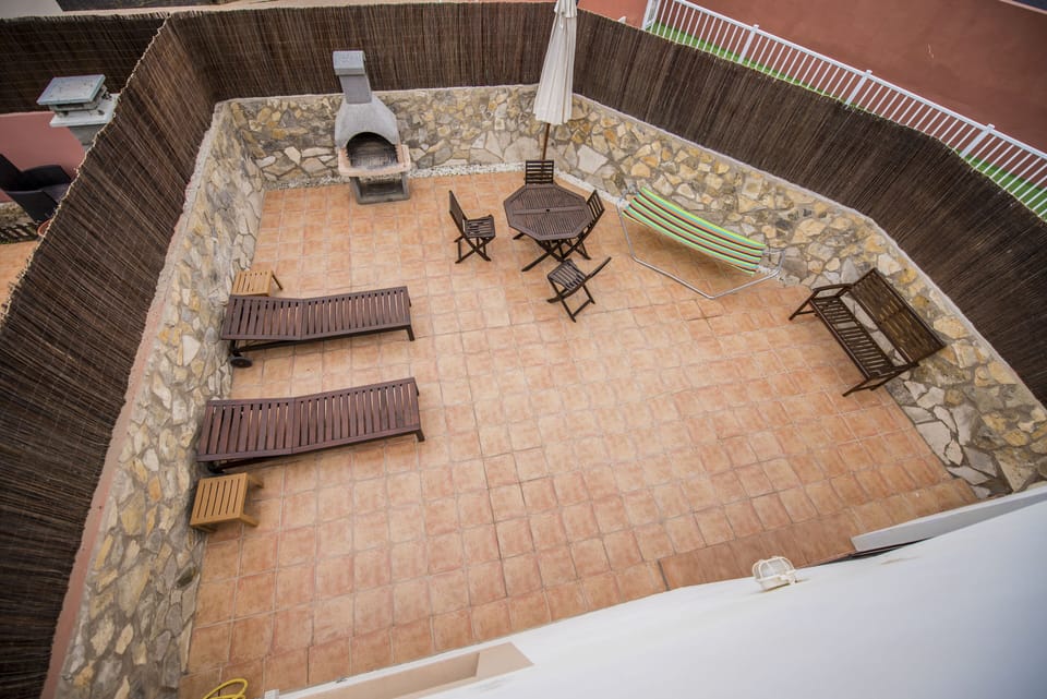 View down (from roof top solarium) to large rear terrace with BBQ and sunbeds