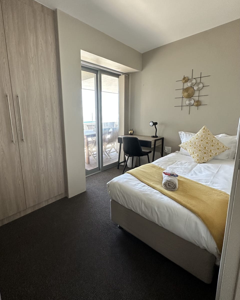 Third bedroom with single bed, cupboard and sliding door to patio