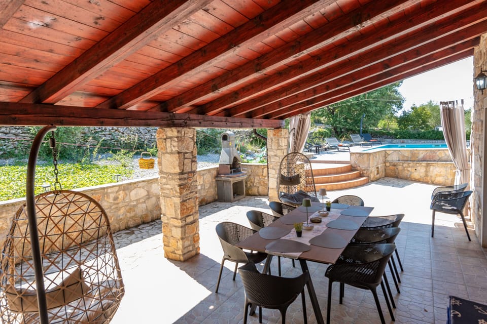 Large dining table on the outside terrace with a charcoal grill