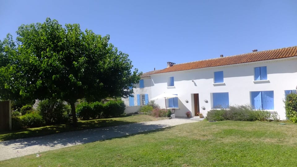House with shutters closed showing the adjoining house used as a holiday home.