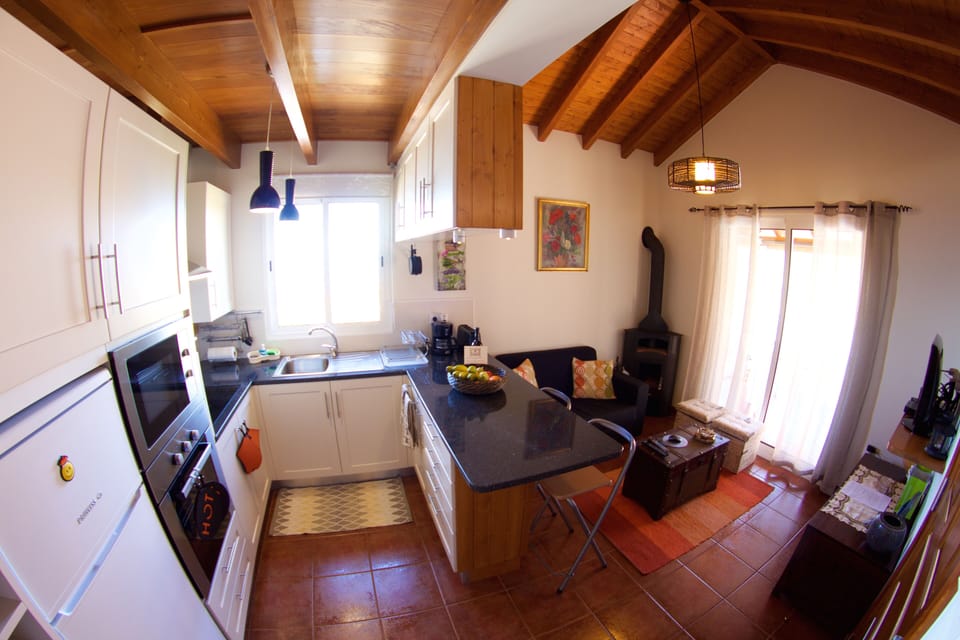 Cozinha e sala com lareira e televisão