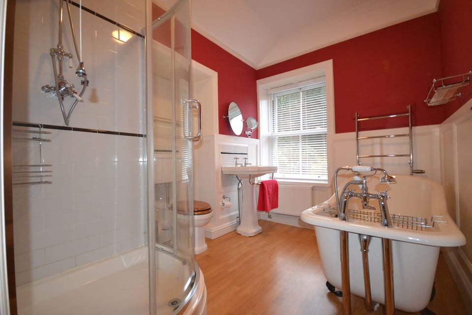 Family bathroom with roll top bath and walk in shower.