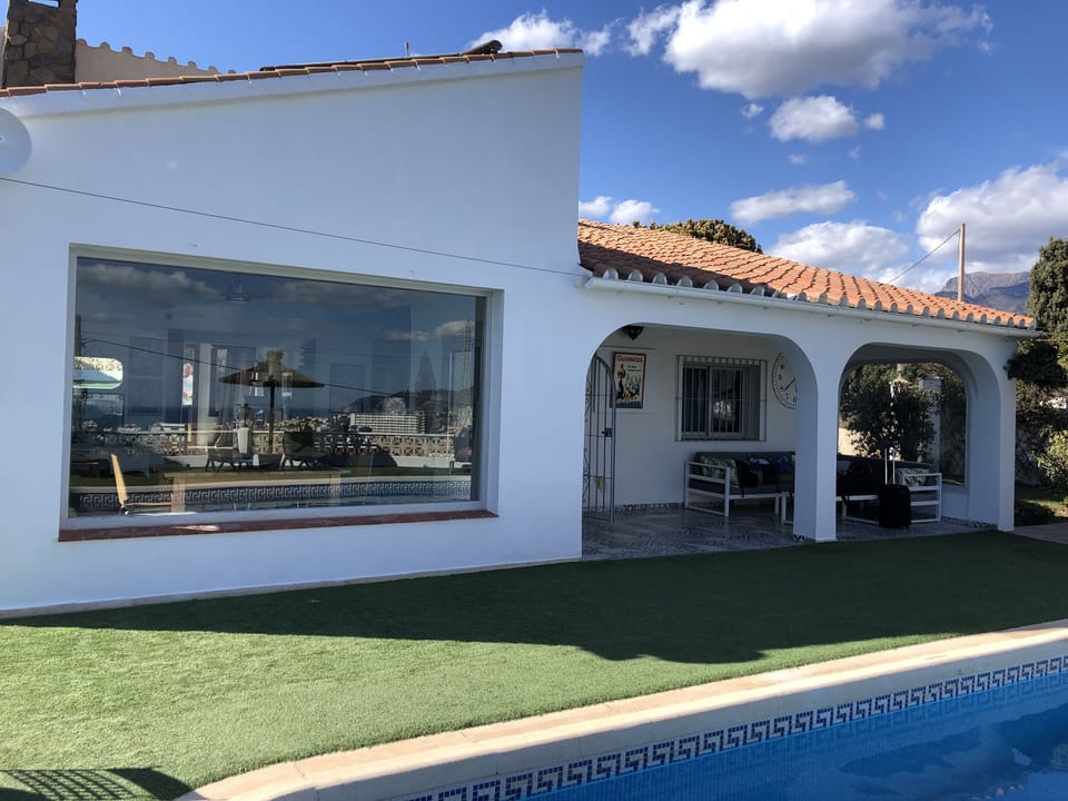 A huge picture window with sea and mountain views dominates the villa facade.