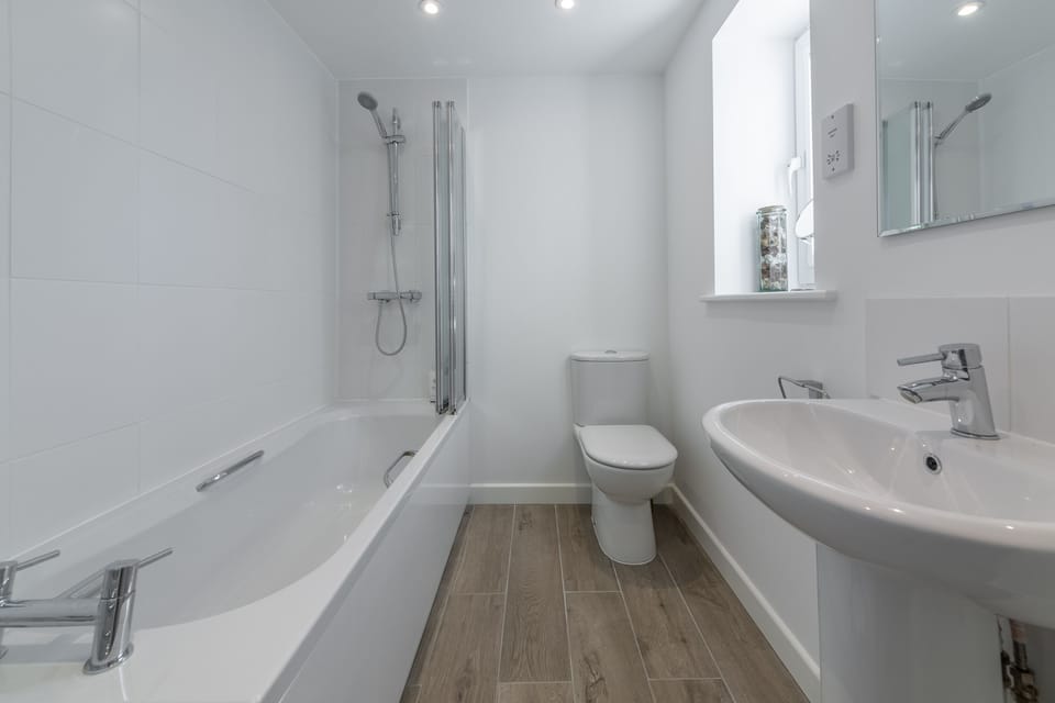 Ground floor: Bathroom featuring bath with shower over