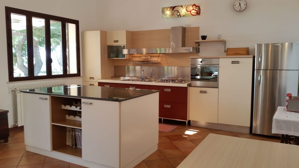 A very spacious, fully equipped kitchen diner with polished stone-topped island