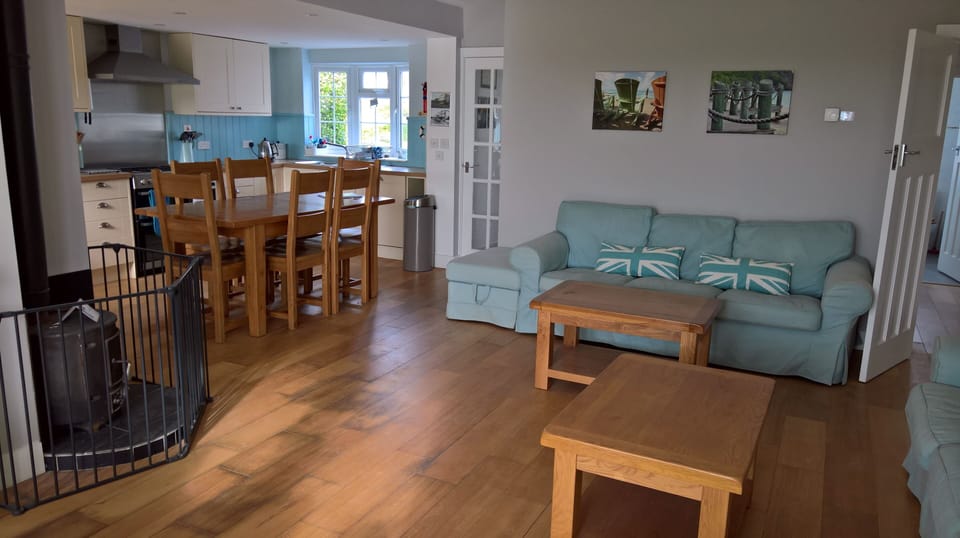 Open plan kitchen/ dining/sitting room with bi-fold doors to garden decking area