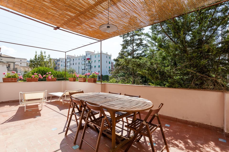 Terrace with dining area, sun beds, beach chairs, and view on internal garden.