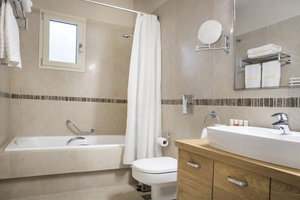 Double bedroom on lower ground floor has a large bathroom with shower in bath.