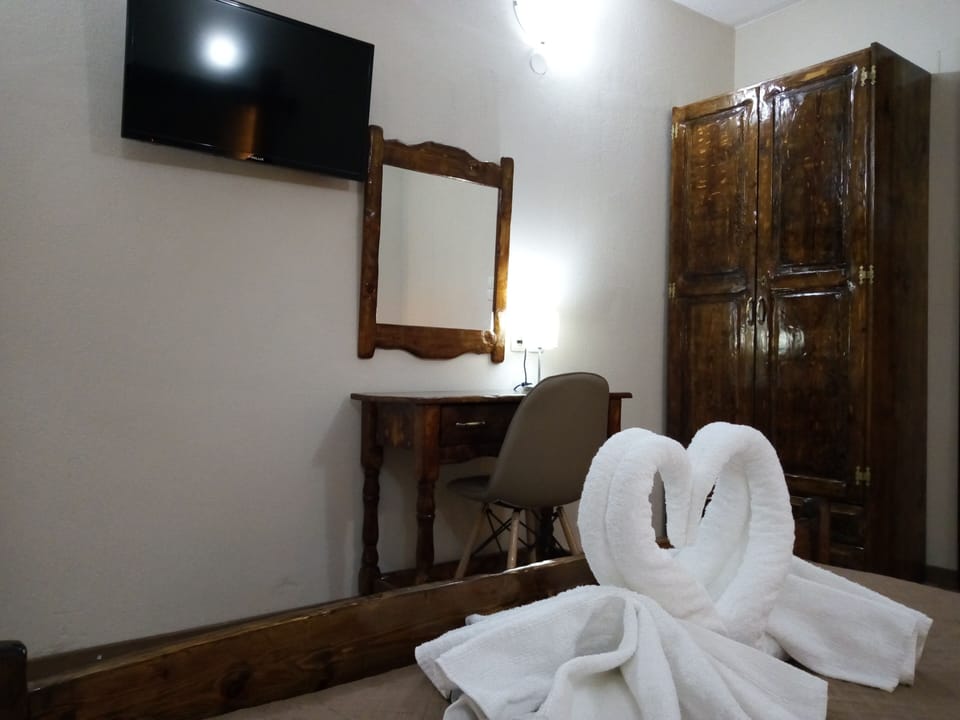 Master bedroom with traditional rustic furniture and satellite TV 