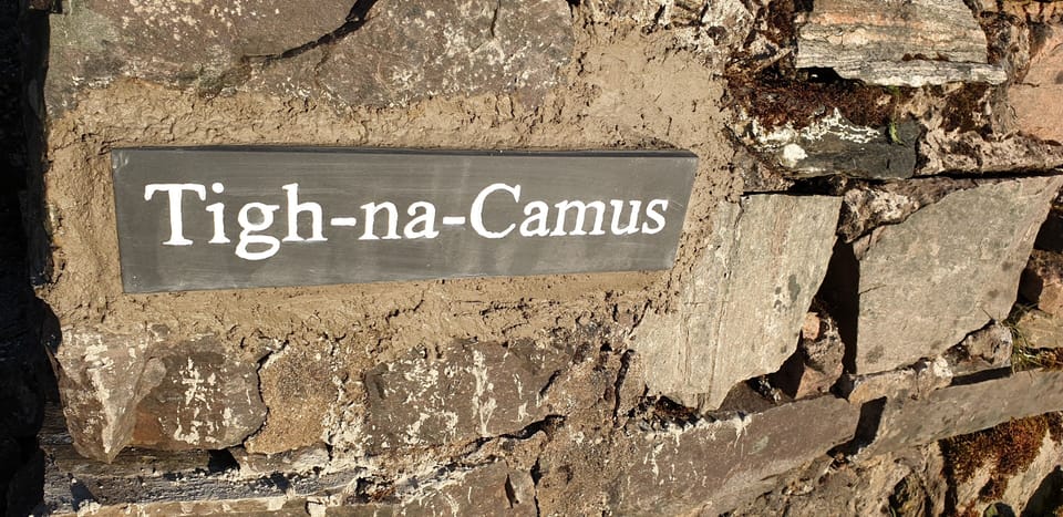 Tigh-na-Camus sign on its dry stone wall at the front of the house