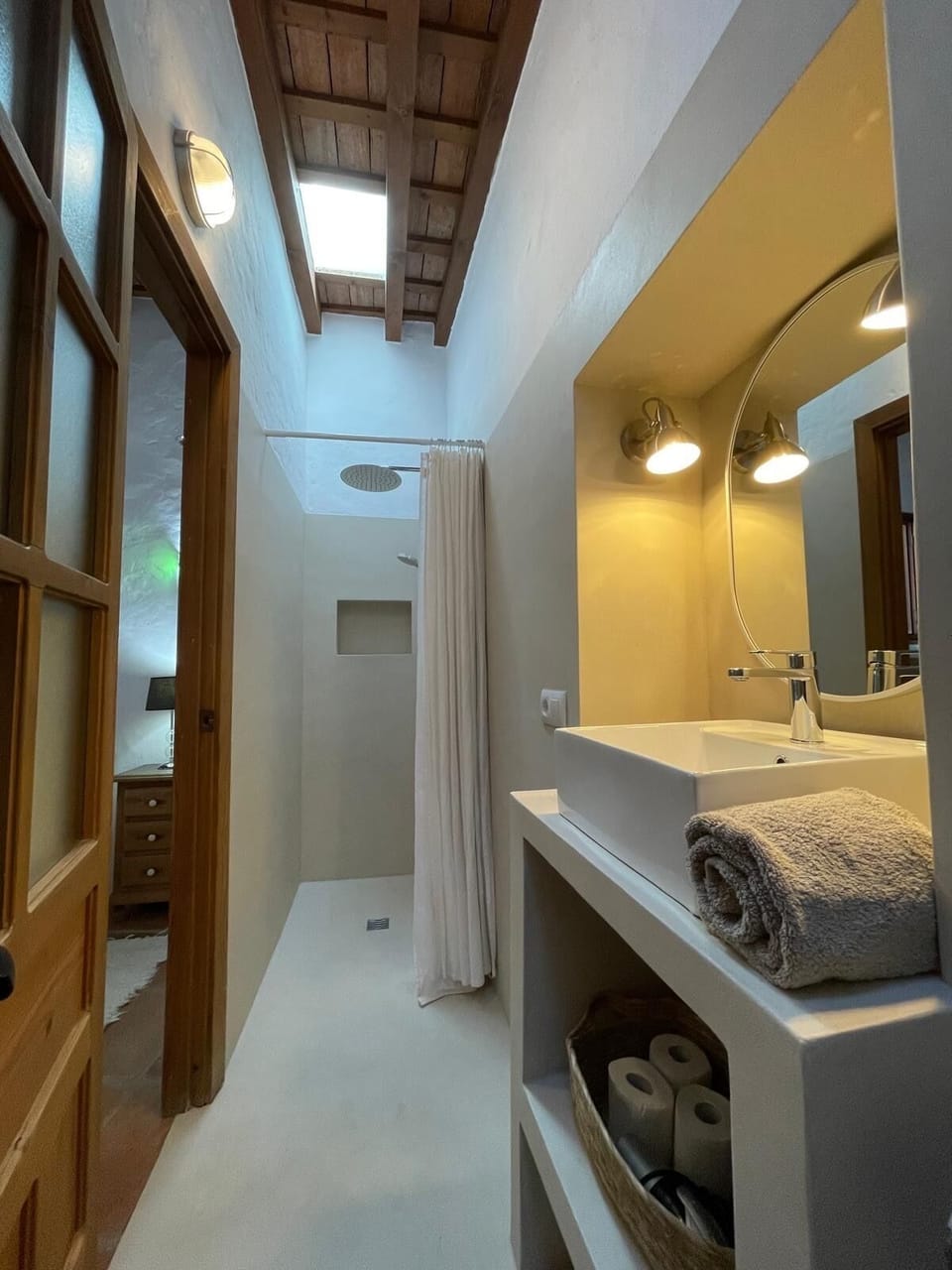 En-suite bathroom with micro-cement finish and rainforest shower