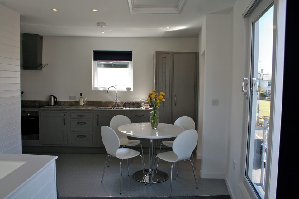 White glass topped circular dining table-  dinning area can seat up to six.