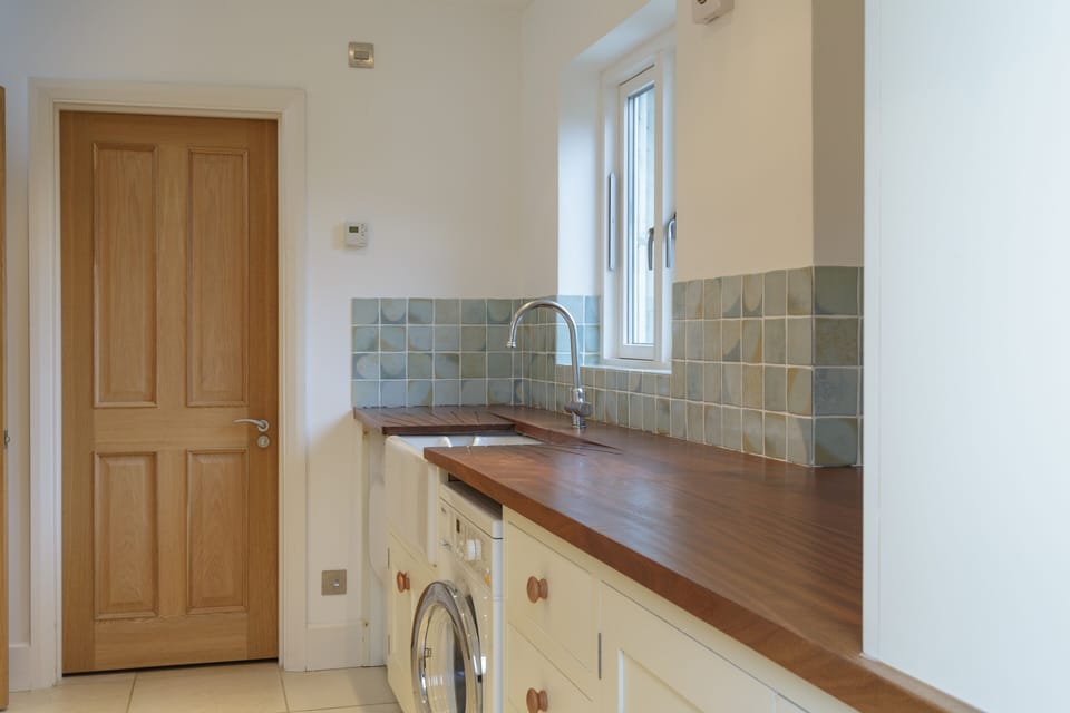 Utility room with Miele washing machine, drier, Belfast sink and drying rack