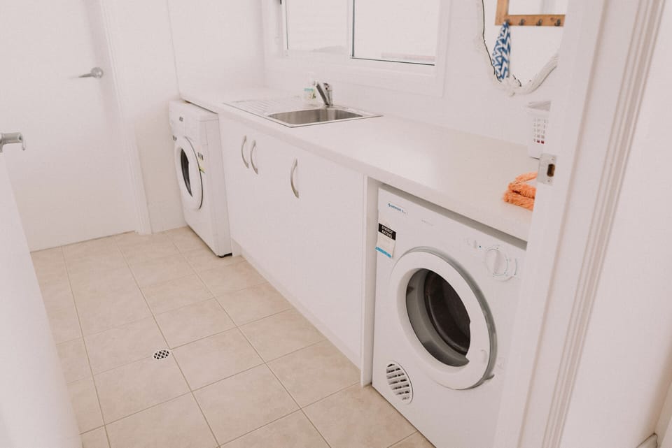 laundry with washer and dryer and second toilet 