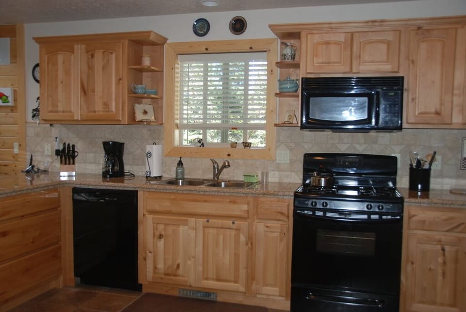 The kitchen features gas range, microwave, dishwasher, lots of dishes & cookware