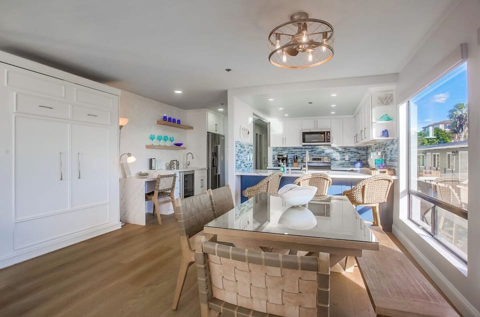 Interior seating for 6 with long bench and 4 chairs. Murphy bed pictured in cabinet to the left, pulls down and out for a queen bed accommodation
