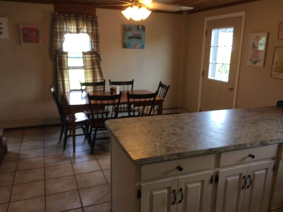 view of breakfast bar and dining from kitchen; side door to deck